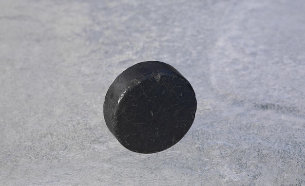 zwarte hockeypuck op ijs