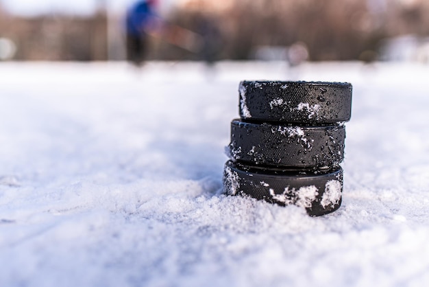 Zwarte hockeypucks liggen op ijs in het stadion