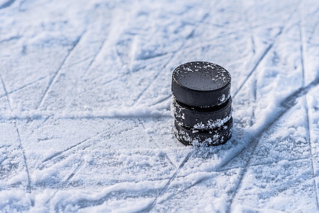 Zwarte hockeypucks liggen op ijs in het stadion