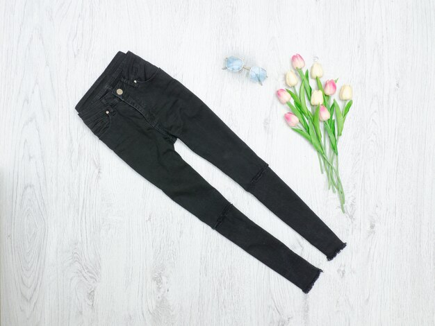 Zwarte jeans en boeket tulpen. Modieus concept