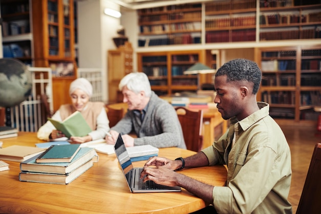 Zwarte jonge man studeert in bibliotheek