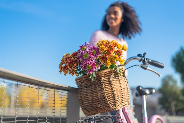 Zwarte jonge vrouw die een uitstekende fiets berijdt