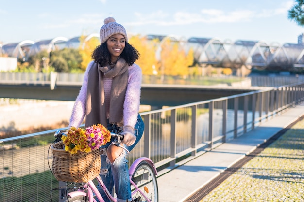 Zwarte jonge vrouw die een uitstekende fiets berijdt