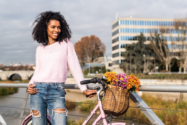 Zwarte jonge vrouw die een uitstekende fiets berijdt