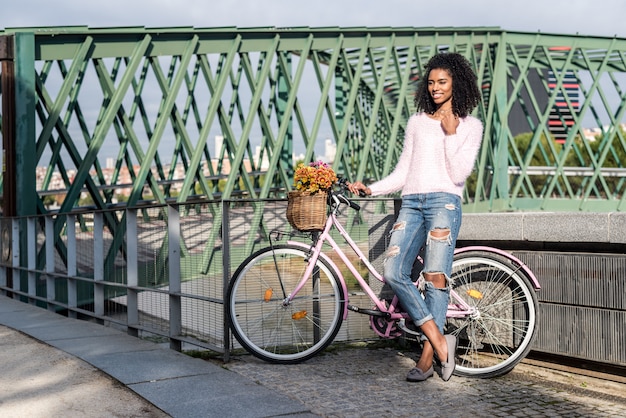 Zwarte jonge vrouw die een uitstekende fiets berijdt