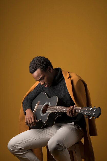 Zwarte jongen die de gitaar speelt