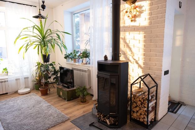 Zwarte kachel open haard in interieur van huis in loft-stijl Alternatieve milieuvriendelijke verwarming warme gezellige kamer thuis brandend hout