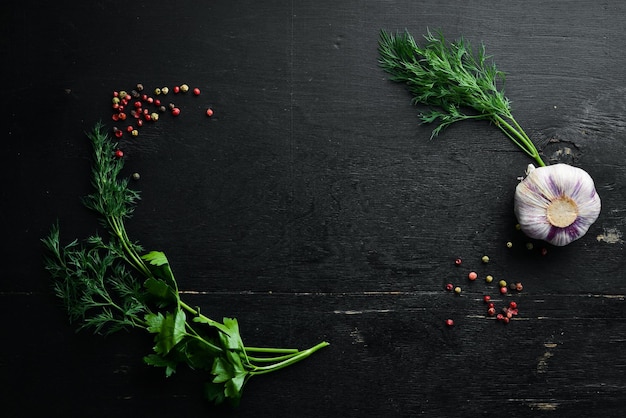Zwarte keukenbanner: groenten en kruiden op een zwarte stenen achtergrond. Bovenaanzicht.