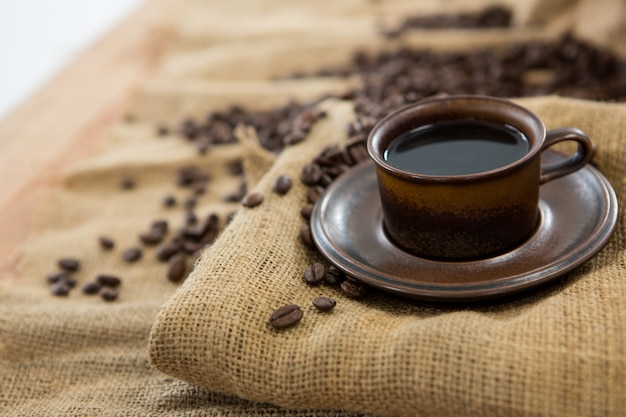 Zwarte koffie die op zak met koffiebonen wordt gediend