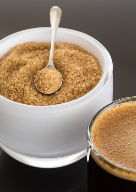 Foto zwarte koffie en schuim in glazen mok met suiker