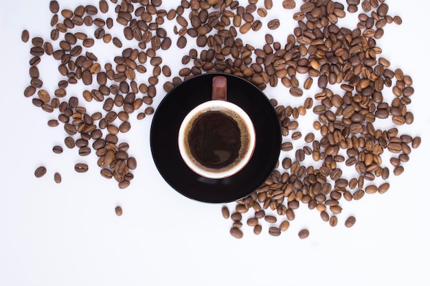 Zwarte koffie in de bruine kop en gebrande koffieboon op de witte achtergrond Bovenaanzicht Kopieer ruimte