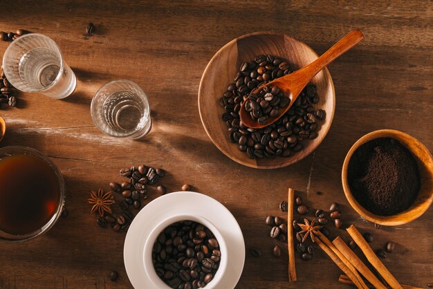 Zwarte koffie in een kopje op het oppervlak van koffiebonen in een compositie met toebehoren