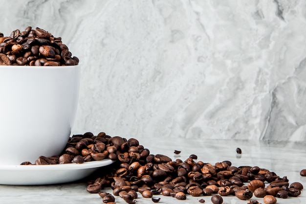 Zwarte koffie in kop en koffiebonen op marmeren achtergrond. Bovenaanzicht, ruimte voor tekst