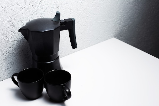 Zwarte koffie mokka pot en twee kopjes, op wit.