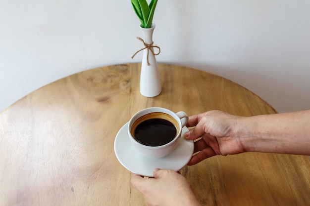 Zwarte koffiekop in de hand