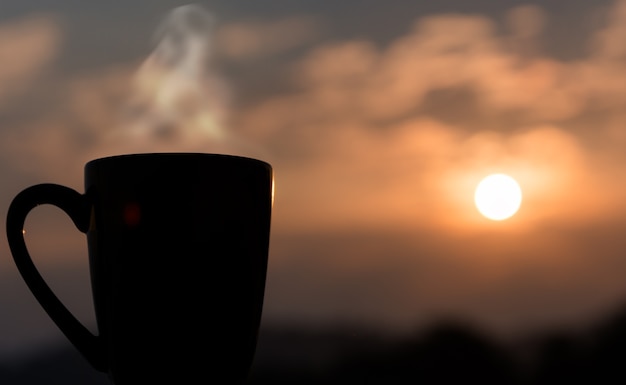 Zwarte koffiekop met avond lichte ruimteachtergrond