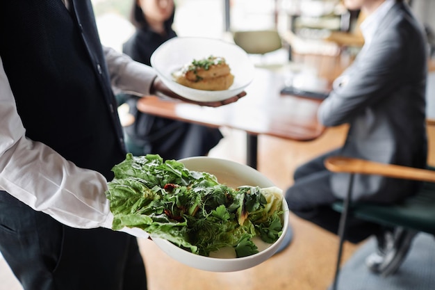 Zwarte man als serveerster die eten op een dienblad brengt