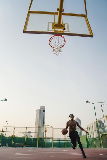 Zwarte man die basketbal speelt.