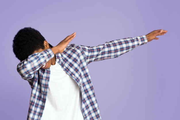 Zwarte man die een dab gebaar maakt en plezier heeft op een roze achtergrond.