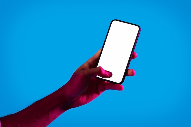 Zwarte man hand met mobiele telefoon met leeg scherm mockup