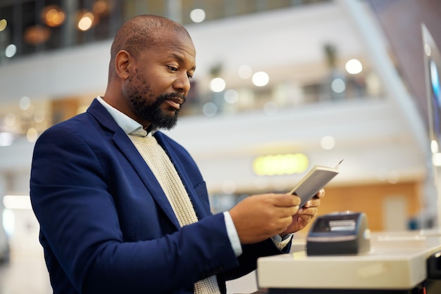 Zwarte man leest paspoort en luchthaven voor reisveiligheid en identiteit voor wereldwijde transportdienst Afrikaanse zakenmandocumenten en conciërge voor immigratie met internationaal transport