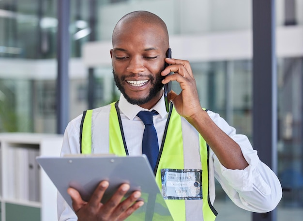 Zwarte man met klembordtelefoontje voor communicatie tijdens inspectie, veiligheidscontrole en naleving Logistiek of constructie met smartphonetechnologie en checklist voor zakelijke kwaliteitsborging