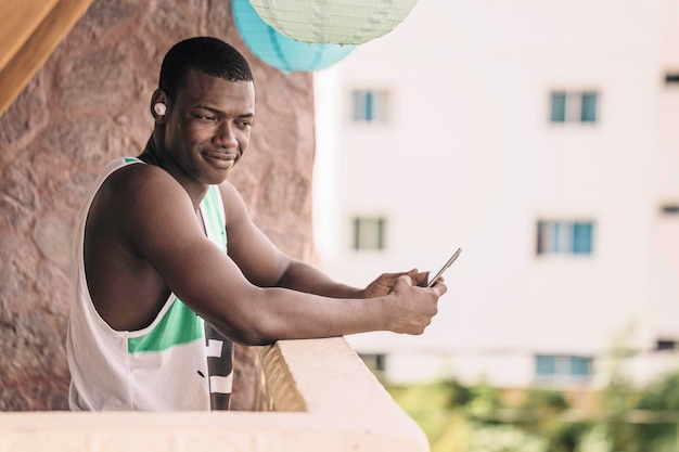 Zwarte man met smartphone op terras