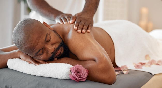 Zwarte man spa en luxe rugmassage tijdens een fysiotherapiesessie of schoonheidssalon Wellness-ontspanning en vredesgevoel van een persoon kalm ontspannen rustend bij massagetherapeut met gastvrijheidszorg