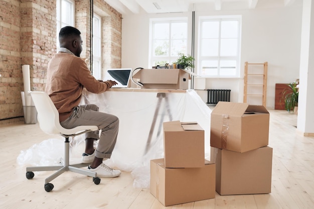 Zwarte manager aan het werk aan tafel bedekt met polyethyleen