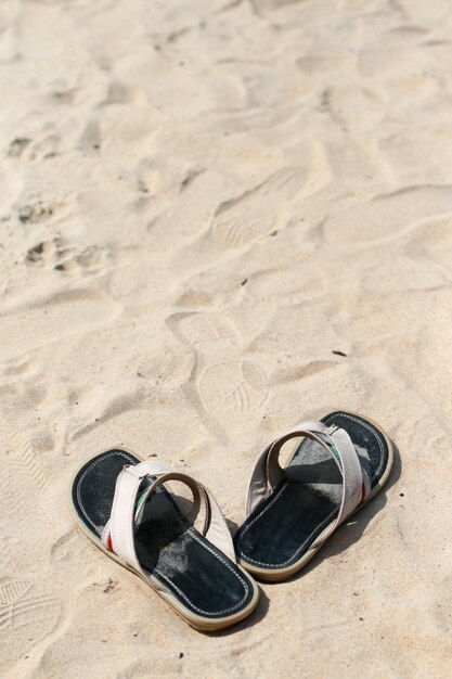 Zwarte mannelijke sandalen die op het zand staan