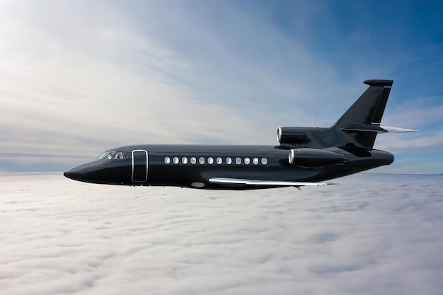 Zwarte moderne luxe executive business jet vliegt in de lucht boven de wolken