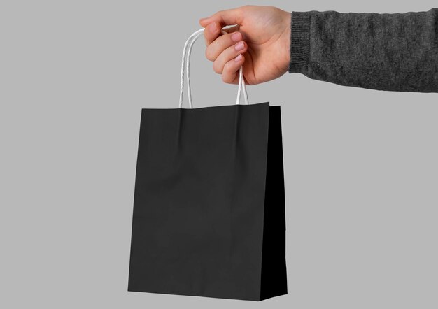 Zwarte papieren zak in de hand