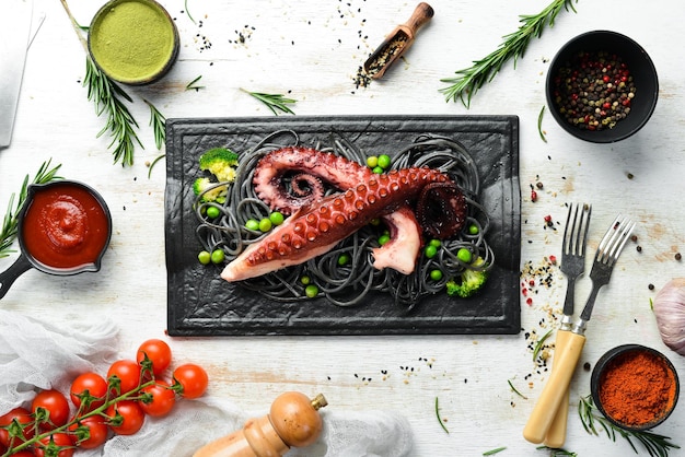 Zwarte pasta met octopus tentakels op een zwarte stenen plaat Zeevruchten Bovenaanzicht Vrije ruimte voor uw tekst