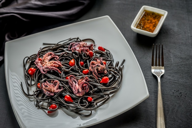 Zwarte pasta met paprika en kleine octopus