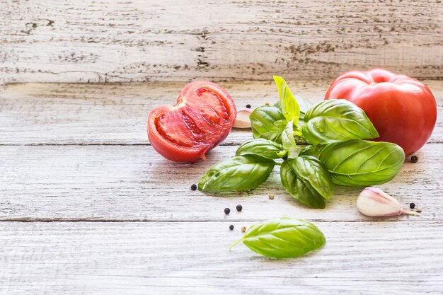 Zwarte peper, knoflook, basilicum en tomaten. Ingrediënten voor het koken.