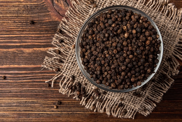 Zwarte peper op een glazen kom op tafel