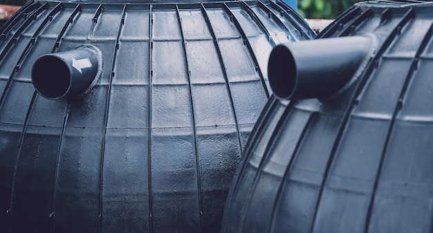 Zwarte plastic wateropslagtanks in het fabrieksdepot van de fabrikant