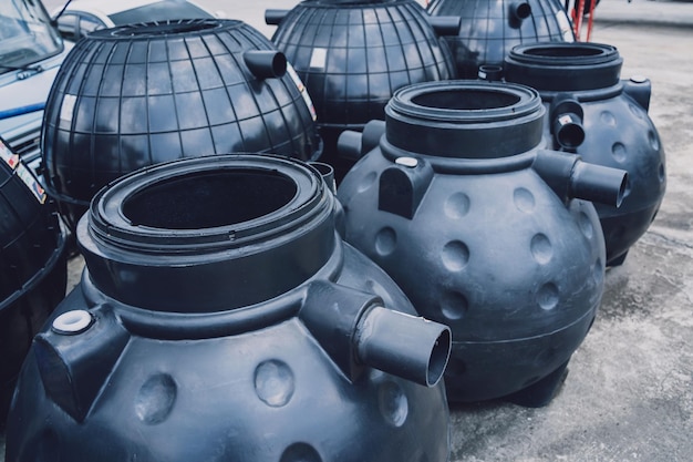 Zwarte plastic wateropslagtanks in het fabrieksdepot van de fabrikant