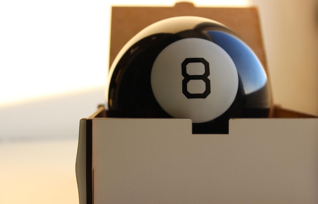 Zwarte poolbal nummer acht in een houten kist close-up stock foto