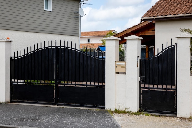 Zwarte poort van klassiek ontwerp europees privéportaal vrijstaand huis in buitenwijkstraat