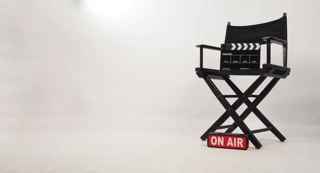 Zwarte regisseursstoel en zwart klepelbord op de stoel en op luchtbox op witte achtergrond