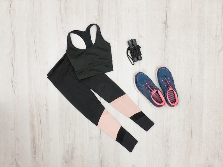 Foto zwarte sporttop, rijbroek en sneakers. modieus sportconcept