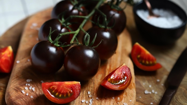 Zwarte tomaten met zeezout op een houten bord