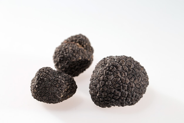 Zwarte truffels die op wit worden geïsoleerd.