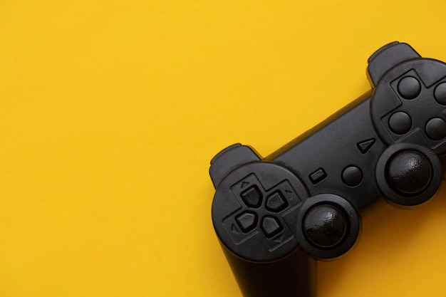 Zwarte videogamecontroller op een felgele achtergrond