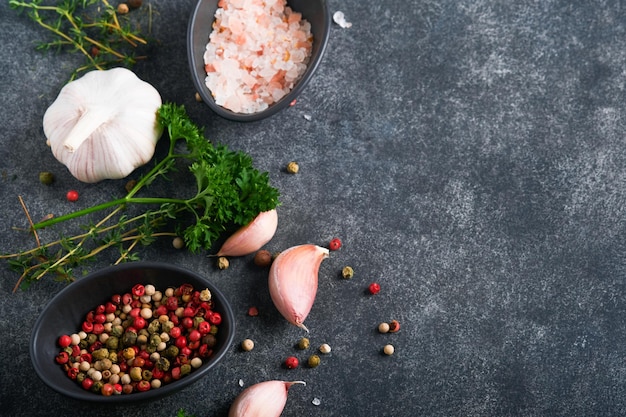 Zwarte voedsel koken achtergrond steen textuur met zeezout peper knoflook en peterselie abstracte voedsel achtergrond lege ruimte voor tekst kan worden gebruikt voor voedsel posters ontwerp van menu bovenaanzicht