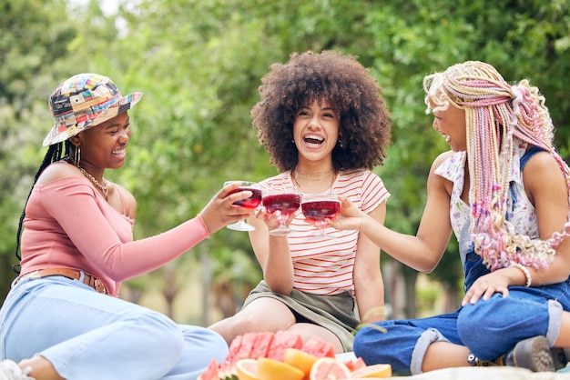 Zwarte vrouw cocktail en vrienden ontspannen op picknick voor vrede, wellness en vriendschap reünie met alcohol glas drinken Natuurpark bomen en gelukkige gen z mensen hechting buiten plezier en glimlach