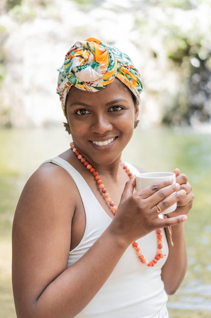 Zwarte vrouw die koffie drinkt in het bos