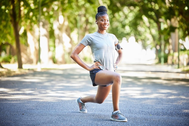 Zwarte vrouw fitness en benen strekken ter voorbereiding op het uitvoeren van cardio-oefeningen of trainingen in de natuur