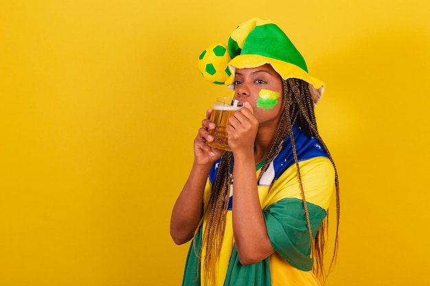 Zwarte vrouw jonge Braziliaanse voetbalfan bier drinken en vieren